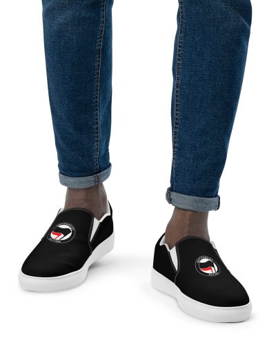 Step into activism with our Antifascist Action Men’s Slip-on Canvas Shoes. These sleek black shoes feature the iconic Antifa design, making a bold statement wherever you go. With elastic side accents for easy wear, a breathable lining keeps your feet comfortable all day long. The soft insole adds extra cushioning.