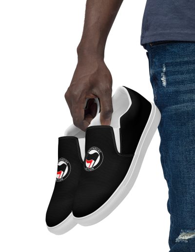 Step into activism with our Antifascist Action Men’s Slip-on Canvas Shoes. These sleek black shoes feature the iconic Antifa design, making a bold statement wherever you go. With elastic side accents for easy wear, a breathable lining keeps your feet comfortable all day long. The soft insole adds extra cushioning.